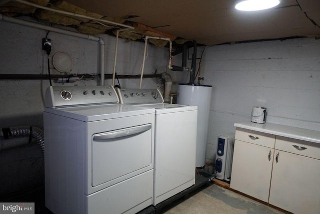 clothes washing area with cabinet space, independent washer and dryer, and water heater