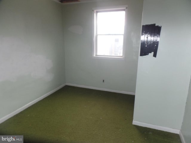 spare room featuring baseboards and carpet floors