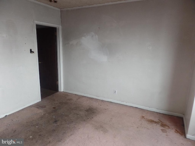 empty room with baseboards and concrete flooring