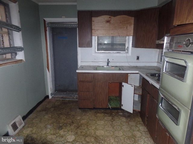 kitchen featuring a sink, visible vents, white double oven, and light countertops