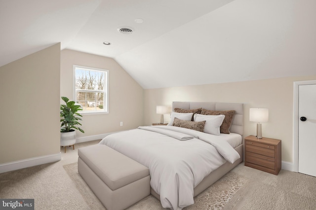 bedroom featuring visible vents, lofted ceiling, light colored carpet, and baseboards