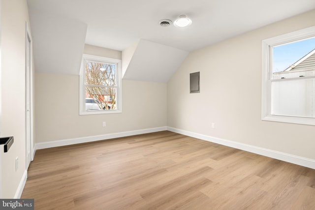 bonus room with light wood finished floors, visible vents, lofted ceiling, and baseboards