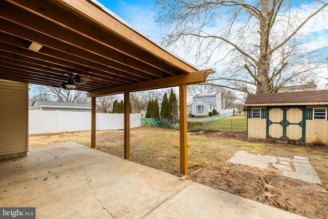 view of patio / terrace with an outbuilding, a storage shed, and a fenced backyard