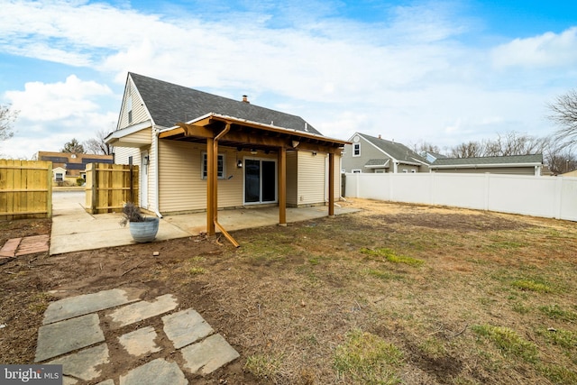 rear view of property featuring a lawn, a fenced backyard, and a patio area