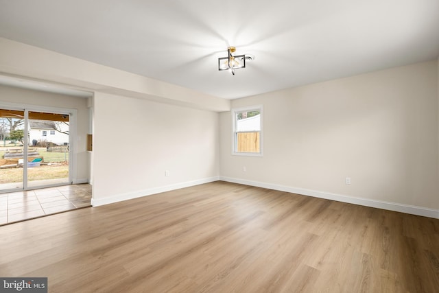 empty room featuring light wood-type flooring and baseboards