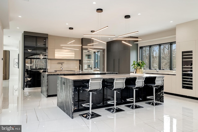 kitchen with backsplash, oven, pendant lighting, a large island, and modern cabinets