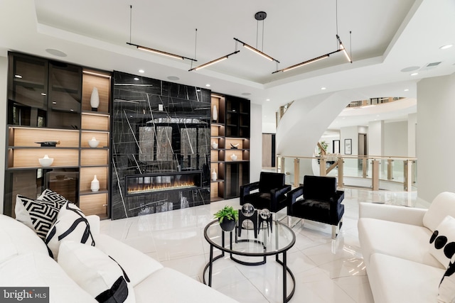 living area featuring recessed lighting, a fireplace, and a raised ceiling