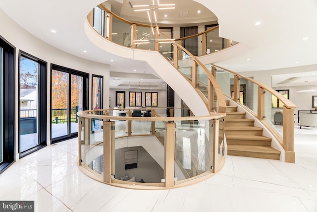 stairway with recessed lighting and a towering ceiling