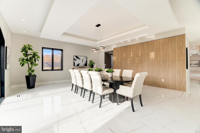 dining room with a tray ceiling, recessed lighting, and baseboards