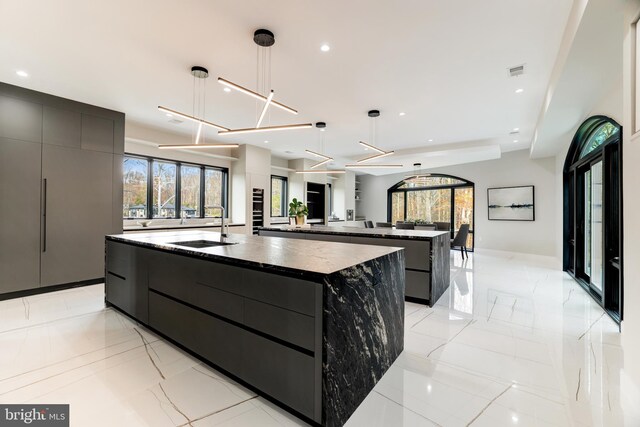 kitchen featuring a large island, visible vents, modern cabinets, and a sink