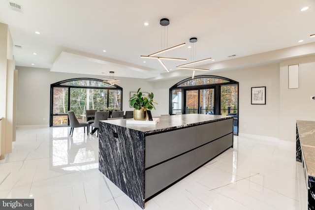 kitchen with visible vents, marble finish floor, recessed lighting, dark stone counters, and baseboards