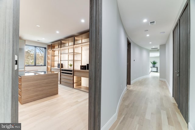 hall with recessed lighting, visible vents, light wood-style flooring, and baseboards