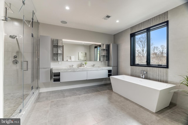 bathroom with visible vents, double vanity, recessed lighting, a stall shower, and a soaking tub