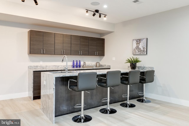 bar with visible vents, track lighting, baseboards, and a sink