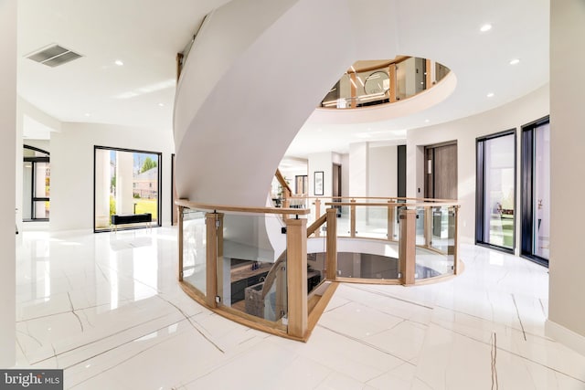 hallway featuring recessed lighting, visible vents, marble finish floor, and stairway