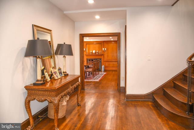 corridor with recessed lighting, baseboards, hardwood / wood-style floors, and stairs