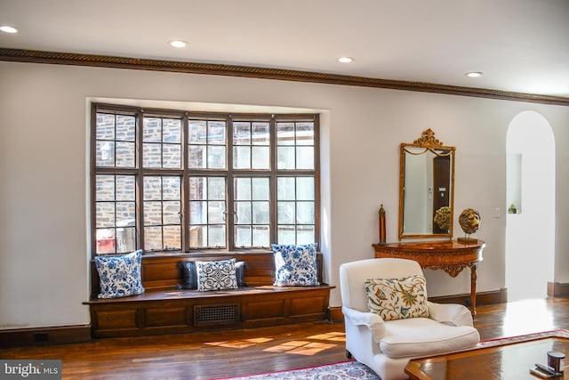 sitting room with visible vents, arched walkways, plenty of natural light, and wood finished floors