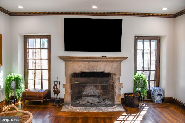 interior space featuring a fireplace with flush hearth, recessed lighting, baseboards, and wood finished floors