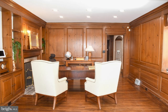 sitting room featuring recessed lighting, wood finished floors, arched walkways, and ornamental molding