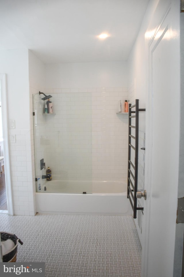 bathroom with tile walls, bathtub / shower combination, and tile patterned flooring