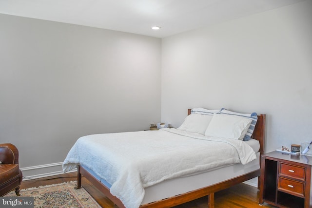 bedroom with recessed lighting, wood finished floors, and baseboards