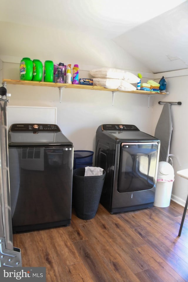 clothes washing area featuring laundry area, independent washer and dryer, and wood finished floors