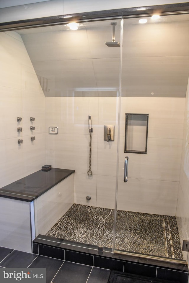 bathroom with a shower stall and tile patterned floors