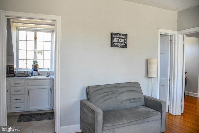 sitting room with baseboards and wood finished floors