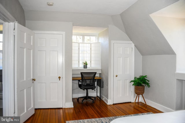 bedroom with built in desk, vaulted ceiling, baseboards, and wood-type flooring