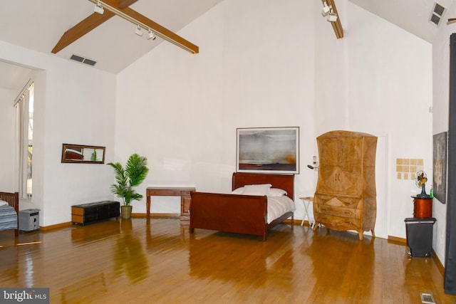 sitting room featuring wood finished floors, visible vents, and high vaulted ceiling