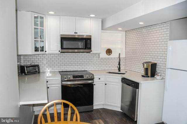 kitchen featuring a sink, appliances with stainless steel finishes, light countertops, and white cabinetry