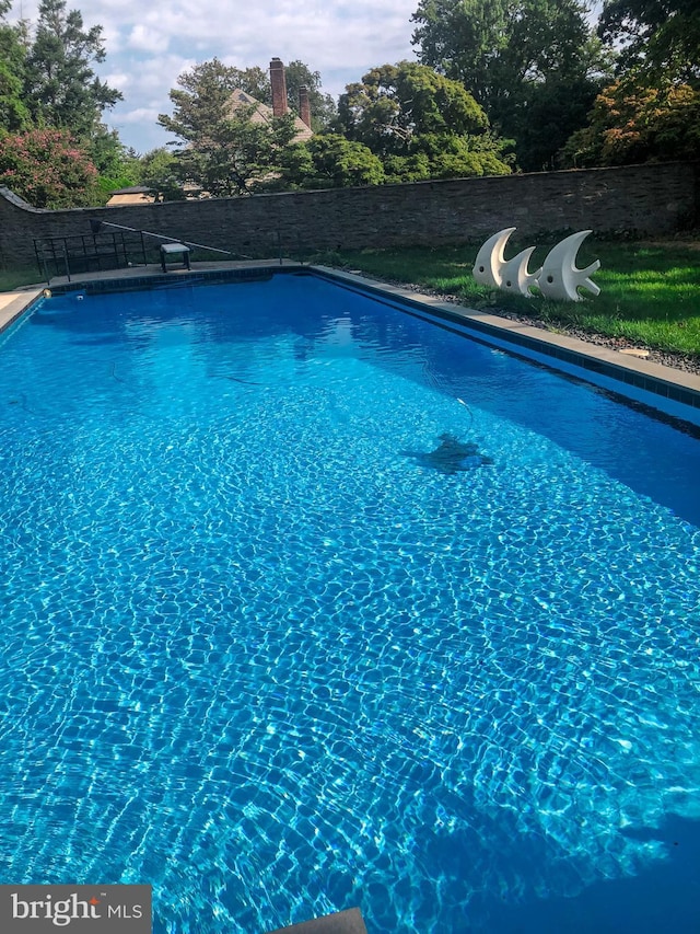 view of swimming pool with a fenced in pool and fence