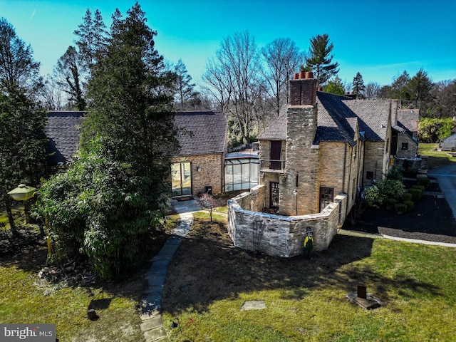 rear view of house with a yard and stone siding