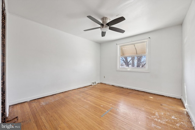 empty room with visible vents, wood-type flooring, baseboards, and ceiling fan