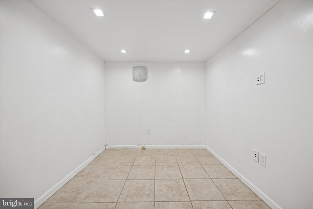 empty room with light tile patterned floors, baseboards, and recessed lighting