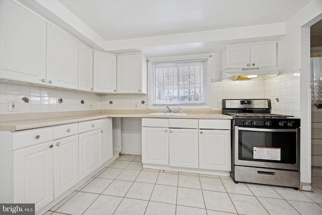 kitchen with tasteful backsplash, stainless steel range with gas cooktop, under cabinet range hood, white cabinetry, and a sink