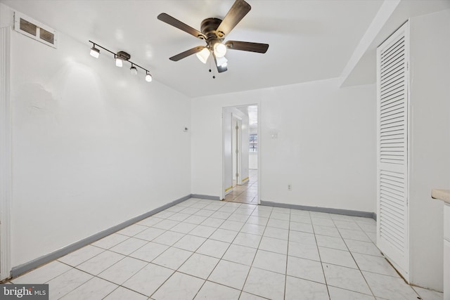 spare room with visible vents, track lighting, a ceiling fan, light tile patterned floors, and baseboards