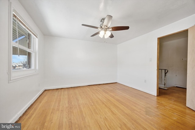 unfurnished room with a ceiling fan, baseboards, and wood finished floors