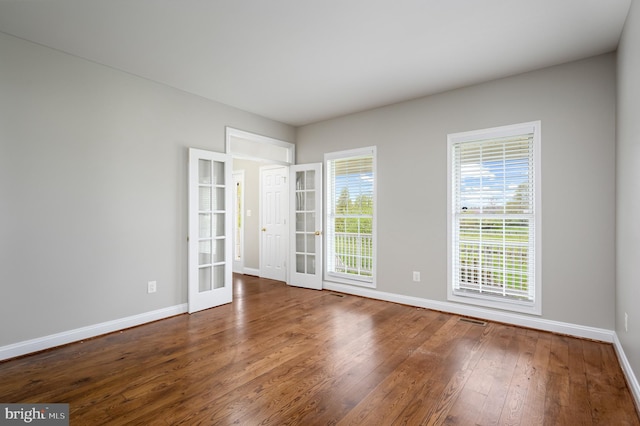 spare room featuring baseboards, visible vents, french doors, and hardwood / wood-style flooring