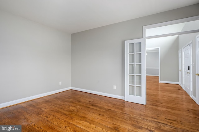 unfurnished room featuring baseboards and wood finished floors