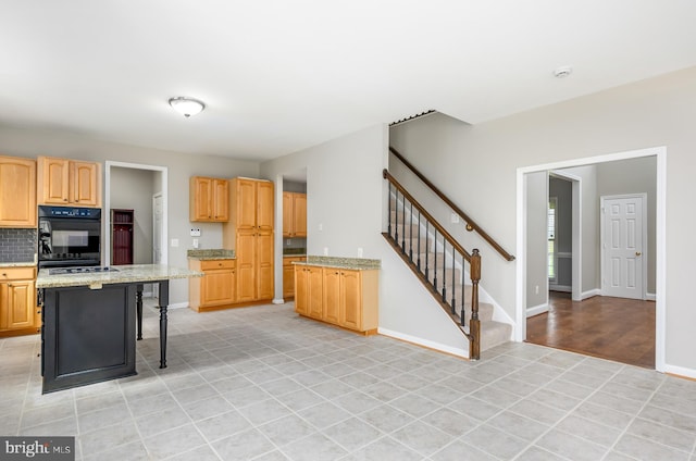kitchen featuring decorative backsplash, light brown cabinets, baseboards, and a breakfast bar