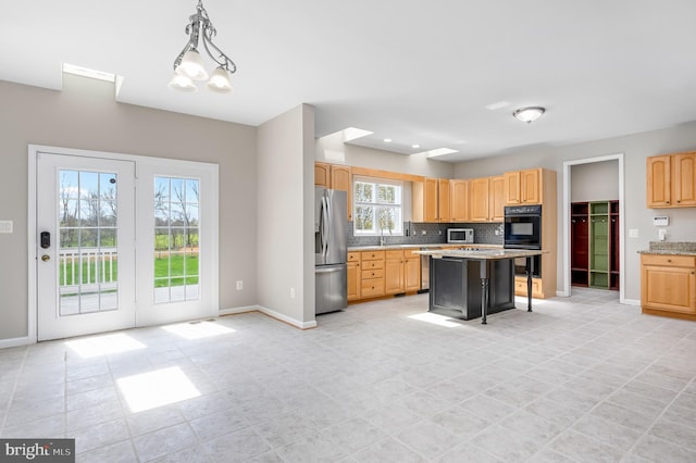 kitchen with backsplash, baseboards, appliances with stainless steel finishes, and a breakfast bar