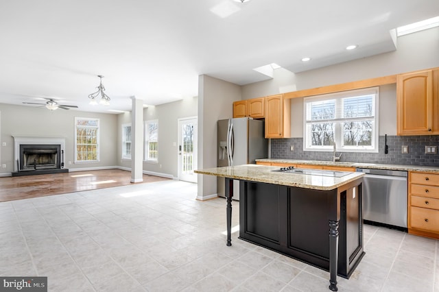 kitchen with appliances with stainless steel finishes, light brown cabinetry, and a healthy amount of sunlight