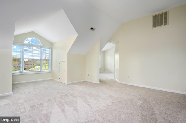 additional living space featuring baseboards, lofted ceiling, carpet flooring, and visible vents