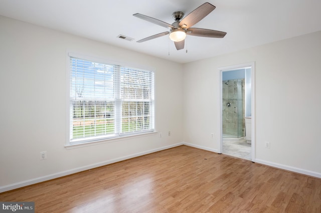 spare room featuring baseboards, ceiling fan, light wood-style flooring, and visible vents