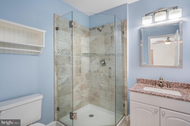 bathroom with vanity, a ceiling fan, toilet, and a shower stall