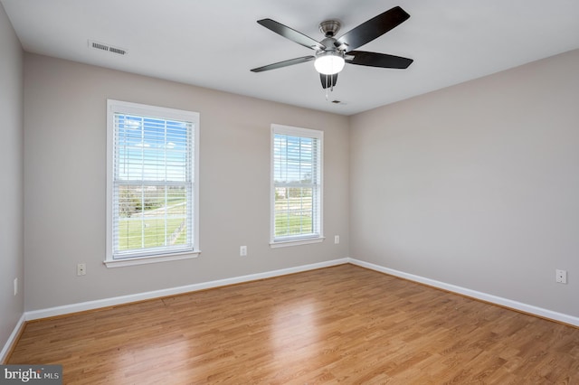 spare room with visible vents, a ceiling fan, baseboards, and light wood-type flooring