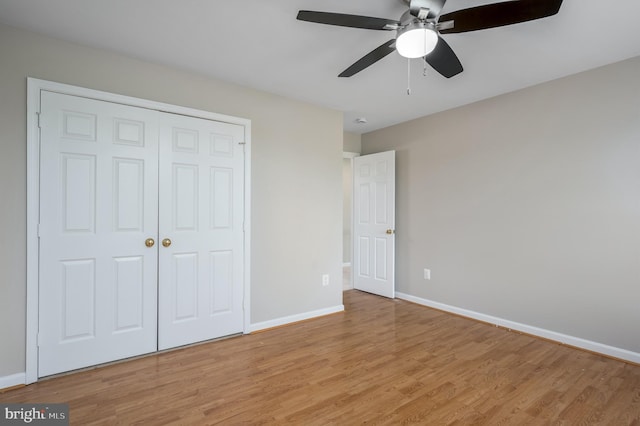 unfurnished bedroom featuring baseboards, ceiling fan, light wood finished floors, and a closet