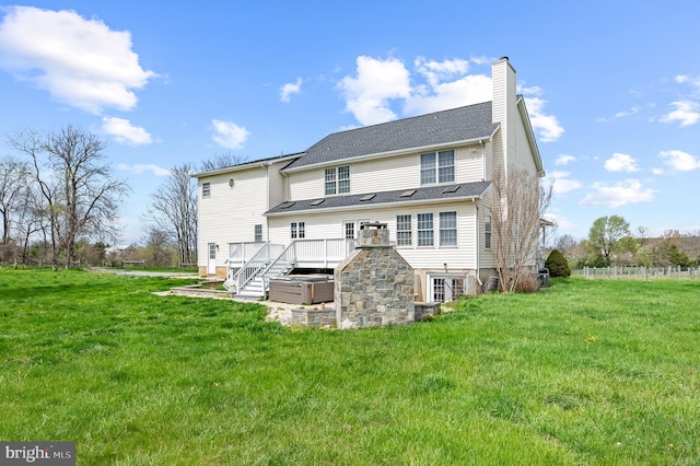 rear view of property featuring a chimney, stairway, a yard, and a deck