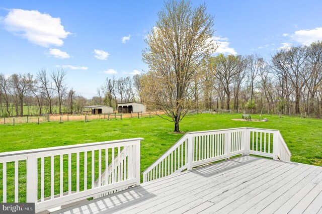 deck with a yard, fence, an outbuilding, and an outdoor structure